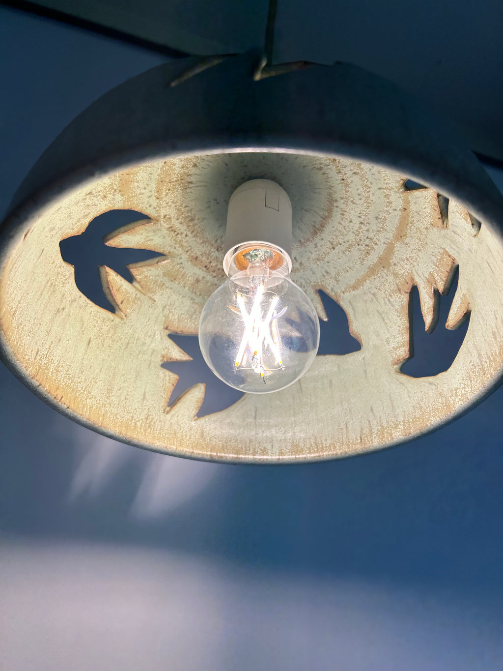 Stoneware green speckled pendant lamp with bird piercings and gold cord