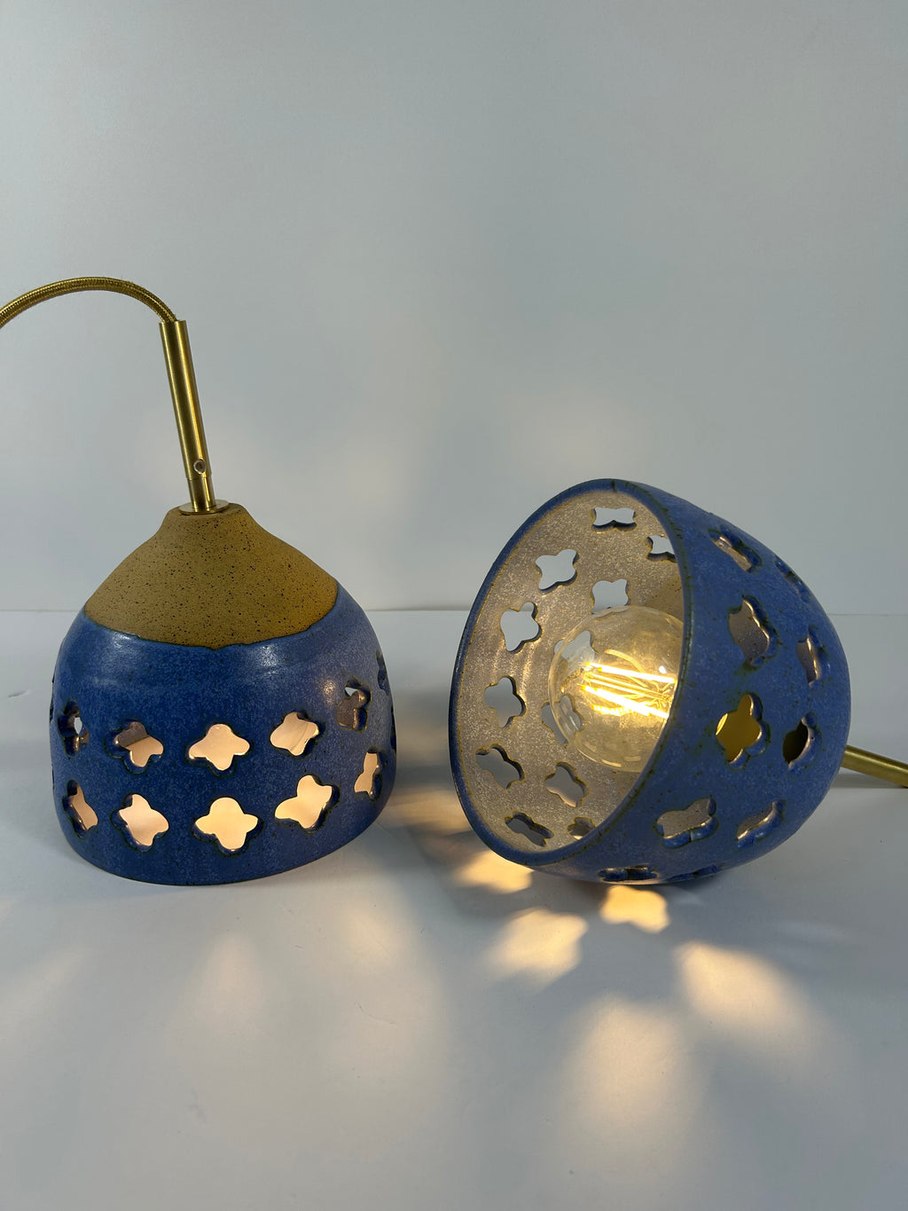 2 Cobalt blue ceramic pendant lamps on speckled clay with gold cord and moroccan piercings