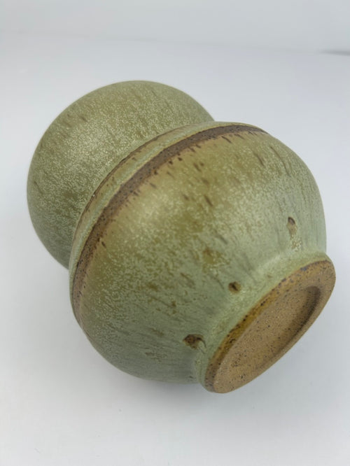 A handmade ceramic vase with a textured sage green glaze and a rustic brown clay band around the center, shown on a plain white background.