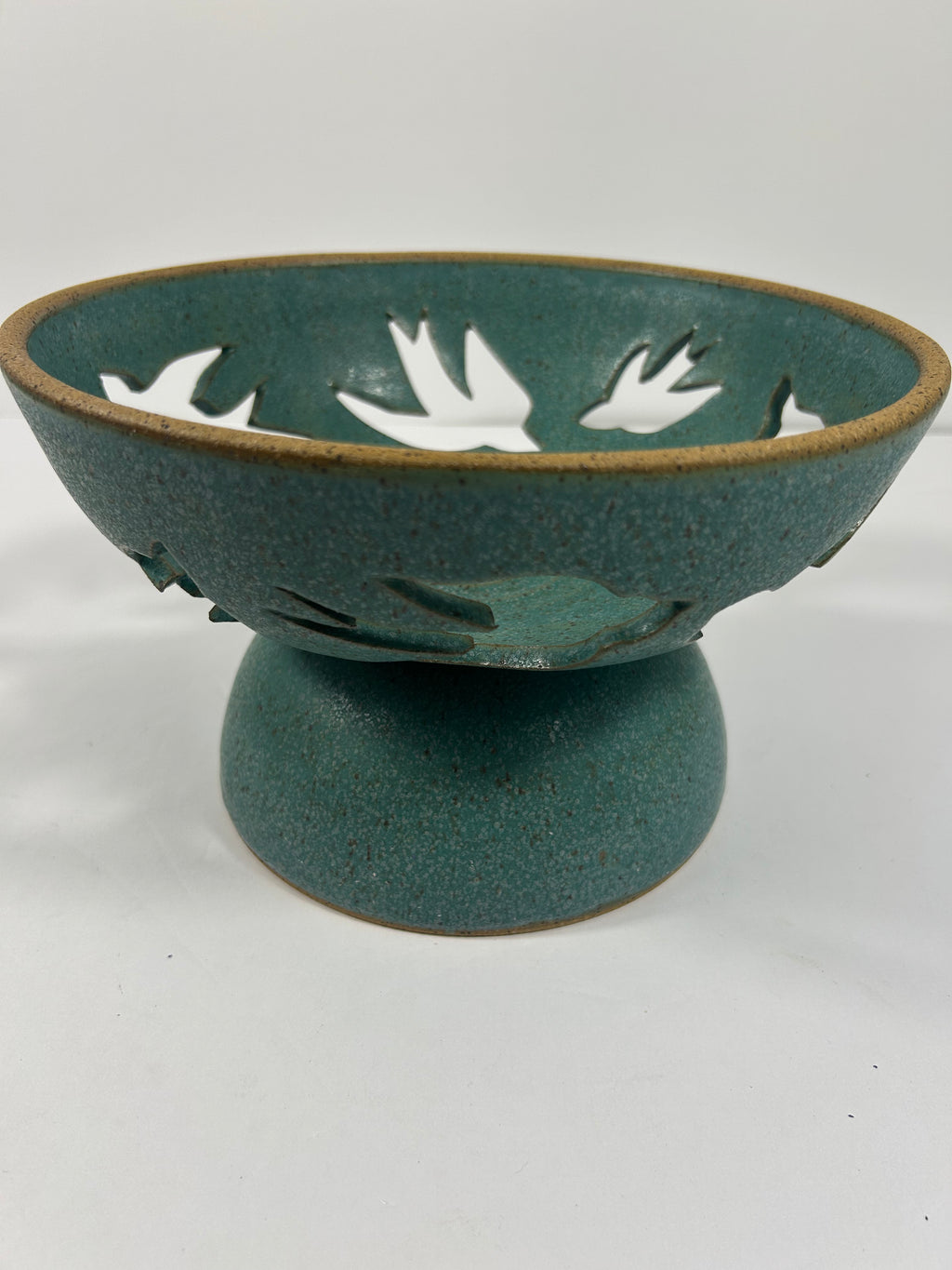 Stoneware teal pedestal bowl with swallow cut-outs 